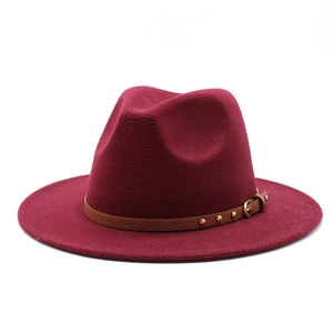 Detailed close-up of a burgundy wool fedora hat featuring a studded leather band and buckle