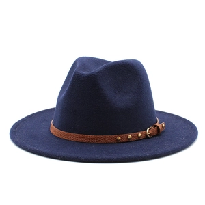 Detail of dark blue wool fedora hat featuring a brown leather strap with gold studs