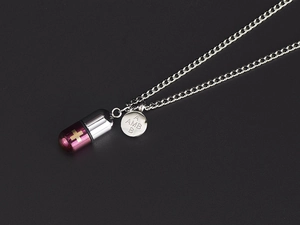 Detalle macro del colgante de cápsula púrpura en cadena de plata con chapa logo