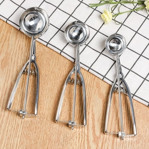 Three sizes of stainless steel ice cream scoops with trigger release on a wooden table