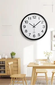 Modern black wall clock with quartz movement displayed in a minimalist dining room decor