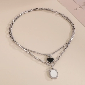 Double-layered silver necklace featuring a black heart and white rectangular pendants