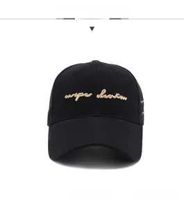 Macro detail of cursive embroidery on a classic black cotton twill baseball cap