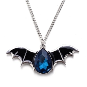 Detailed shot of a silver bat pendant with black enamel wings and a blue pear-shaped gem