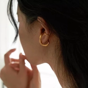 Close-up of a minimalist gold-plated geometric ear cuff worn on the upper ear cartilage