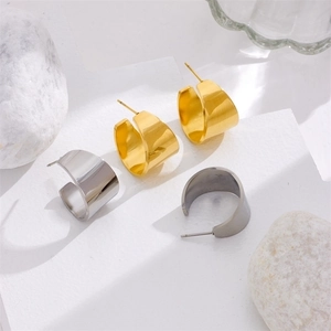 Minimalist C-shape wide metal earrings in polished gold and silver finishes on stone stand