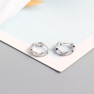 Macro detail of S925 sterling silver huggie earrings with marquise and round zircon stones