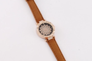 Detail of starry flower rhinestone dial and brown suede strap on a rose gold watch