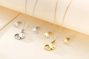 Detail of hollow elephant pendant necklace and matching stud earrings in gold and silver