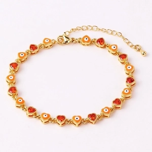 Detailed view of gold heart charms with orange evil eye and red zircon on a hip hop bracelet