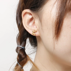Orecchini a perno a forma di cervo dorati alla moda indossati da una modella in primo piano
