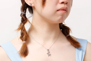 Dettaglio del set collana e orecchini a forma di renna d'argento indossato da modella