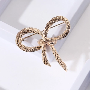 Detail showing the golden rope texture and oil-dripping craft on the bow-knot brooch