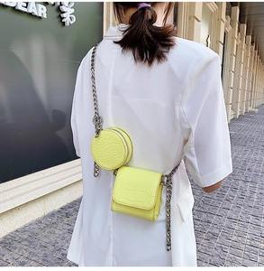 Detail of neon yellow crocodile embossed leather crossbody bag with silver chain strap