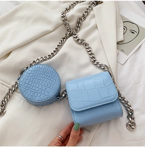 Detail of light blue crocodile pattern crossbody bag set with chunky silver chain link