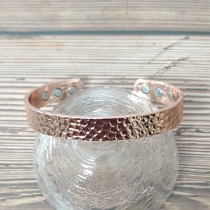 Rose gold copper magnetic bracelet with wave pattern and magnets on clear stand