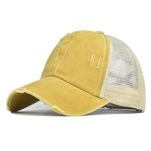 Détail du tissu en coton jaune délavé et de la maille beige sur une casquette ponytail