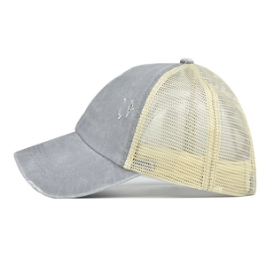 Détail de profil d'une casquette en denim délavé avec effet vieilli et arrière en filet