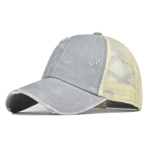 Détail d'une casquette délavée grise avec maille beige respirante et finitions usées