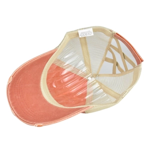 Détail de la casquette orange avec filet arrière et étiquette de composition en coton