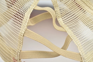 Détail de la casquette beige avec élastiques croisés pour queue de cheval à l'arrière