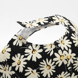 Black baseball cap with daisy floral print featuring adjustable velcro strap back closure