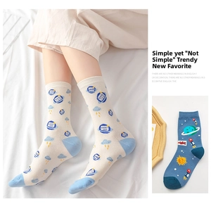 Detail of space rocket and planet patterns on blue and white cotton crew socks