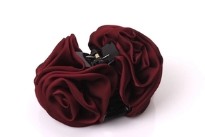 Close-up of wine red satin rose hair claw clip with detailed fabric floral texture