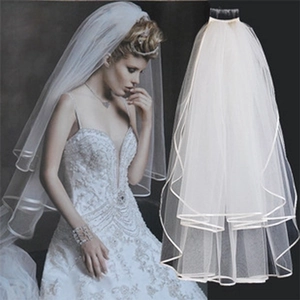 Close-up of double layer white bridal veil with elegant satin ribbon edge detailing