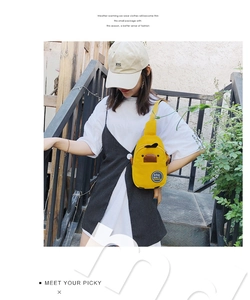 Outdoor model shot showing the yellow canvas cartoon duck crossbody bag detail