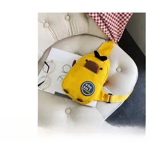 Detailed close-up of yellow canvas duck chest bag with round patch on a sofa