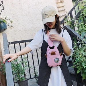 Detailed outdoor shot of a pink canvas duck crossbody chest bag worn by a model