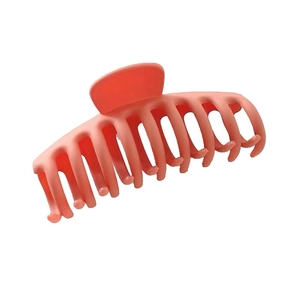 Macro view of a large red plastic shark hair claw clip for French twist styling