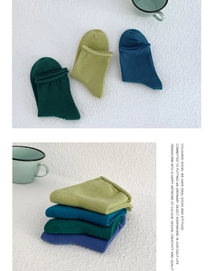 Detailed close-up of colorful knitted cotton socks in vibrant green and blue shades