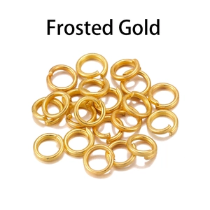 Macro shot of frosted gold open jump rings for jewelry making on white background