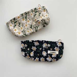 Floral embroidered makeup bags in beige and black with white daisy patterns