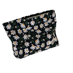 Black canvas cosmetic bag with white daisy embroidery and zipper closure for women