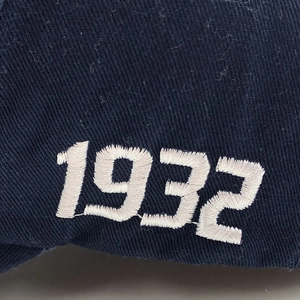Detailed close-up of white 1932 embroidery on navy blue washed cotton baseball cap