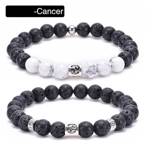 Macro shot of Cancer zodiac bracelets with black lava and white turquoise beads