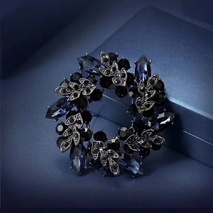 Detail of vintage wreath brooch with deep blue crystals and silver leaf ornaments