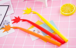 Detail shot of three maple leaf shaped gel pens in red yellow and orange colors