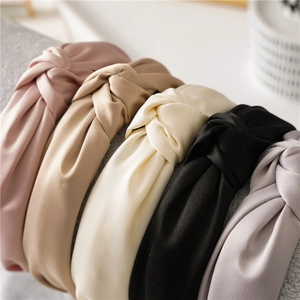 Close-up of knotted satin headbands in pink, beige, black and lilac on display
