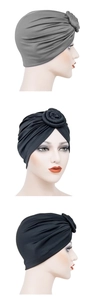 Detail of grey and black pleated turban hats with knotted donut flower design