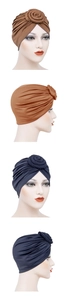 Detail of floral pleated knot design on milk silk turban hats in brown and navy blue