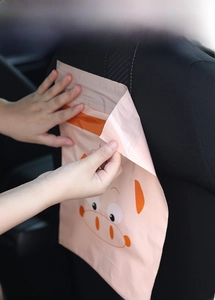 Detail of pink cartoon car trash bag being removed from car seat without leaving any residue