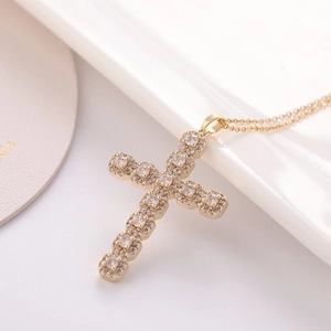 Gold cross pendant necklace with sparkling cubic zirconia on a delicate gold chain