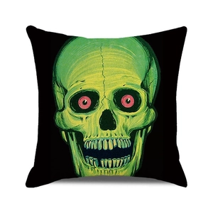 Detail of square cushion cover with green skull and pink eyes print on black background