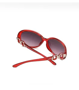 Detail of red translucent sunglasses frame with silver metal chain link decoration