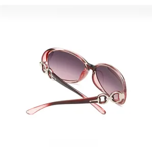 Detail of burgundy translucent oval frame sunglasses with silver metal horseshoe hinge