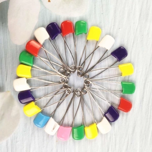 Spille da balia colorate con testa in plastica per neonati disposte in cerchio